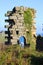 A ruined wall of Treen Cove tin mine with arch stands on the cliff top with Gurnard\\\'s Head Head behind, Cornwall, England