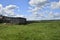 a ruined wooden farmhouse under a blue sky.