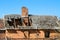 Ruins of abandoned old house with damaged falling roof and chimney on sunny day with clear blue sky