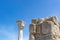 Ruins of ancient antique Greek basilica and columns against a blue sky with white clouds looking up
