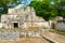 Ruins of ancient Muyil. Architecture of ancient maya. View with temple and other old buildings, houses. Blue sky and lush greenery