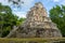 Ruins of ancient Muyil. Architecture of ancient maya. View with temple and other old buildings, houses. Blue sky and lush greenery