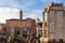 Ruins of ancient roman temple in front of medieval church facade in Rome