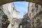 The ruins of an ancient synagogue against the sky. View through the arch to the texture of the old dilapidated masonry. Trees and