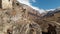 The ruins of ancient towers on a rock in the mountains of Upper Balkaria. Aerial view of the gorge with a dirt road and