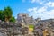 Ruins of ancient Tulum. Architecture of ancient maya. View with temple and other old buildings, houses. Blue sky and lush greenery