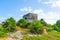 Ruins of ancient Tulum. Architecture of ancient maya. View with temple and other old buildings, houses. Blue sky and lush greenery