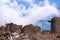 Ruins of ancient windmills on rocky mountains with blue sky with white clouds