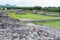 Ruins of the architecturally significant Mesoamerican pyramids and green grassland located at at Teotihuacan, an ancient