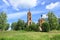 Ruins of belltower and churches in summer meadow in middle part of Russia