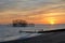 The ruins of Brighton`s West pier silhouetted against a setting sun.