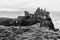 Ruins of Dunluce castle on the cliffs of the Atlantic Ocean in Northern Ireland in black and white