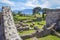 Ruins of the old city of Pompeii with the remains of houses and kitchen utensils pots, vases. Gardens and volcano Vesuvius in th