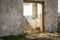 The ruins of an old earthen house without a roof. Holes in the wall at the site of windows and doors