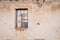 The ruins of an old earthen house without a roof. Holes in the wall at the site of windows and doors