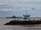 The ruins of the old pier in herne bay with harbour wall and grey sky with flying gull