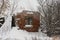 ruins of an old red brick house. The chimney of the stove protrudes from the window. in winter, there is snow all around