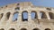 Ruins of the Roman Colosseum. Vehicles and people, left to right pan shot