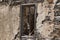 The ruins, the ruins of the destroyed castle fortress wall with a window with iron bars.