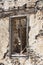 The ruins, the ruins of the destroyed castle fortress wall with a window with iron bars.