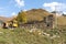 The ruins of a stone residential building and a broken Soviet-era tractor stand at the foot o