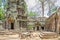 Ruins of temples of Angkor Thom with roots of a spung running along the gallery