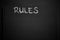 Rules word written on a notepad with blank space. Blank black notepad background