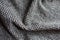 Rumpled grayish brown woolen fabric with diamond pattern