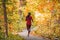Run woman jogging in outdoor fall autumn foliage nature background in forest. Trail running runner athlete training