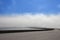 Runde bridge in Norway surrounded by fog with blue sky