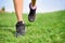 Runner athlete feet running on grass fitness woman