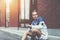 Runner in blue sitting on the street before his early morning workout using smart watches on his hand and armband with smartphone