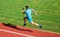 Runner captured in midair. Short distance running challenge. Boost speed. Athlete run track grass background. Run into