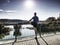 Runner doing stretching exercise on bridge. An active wiry man