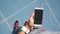 Runner girl using smartphone touching screen choosing music for running on track