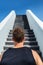 Runner going up stairs running challenge. Fitness man looking ahead at stair climbing. Staircase for cardio goal doing