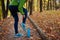 Runner injured leg during workout exercises in autumn park. Woman feels ankle pain and crick