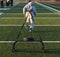 Runner pulling a sled with weights on a turf field