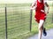 Runner running next to a wire fence during high school cross country race