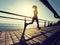 Runner running on seaside boardwalk during sunrise