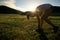 runner tying shoelace on sunset grassland trail