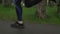 Runner woman jogging alone in city park after rain, close up shot of feet. Female feet running on wet footpath in city park. Legs