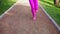 Runner woman running in the park exercising outdoors, close up on feet. Steadicam stabilized shot. Sportswoman training