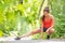 Runner woman stretching leg running workout run girl doing legs stretches outdoor in summer park. Asian athlete warm up prep