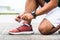 Runner young man tying shoelace getting ready for race on run track