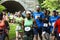 Runners in crowded 10K race on dirt trail in park coming out of a tunnel