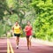 Runners running on road outside two athletes training outdoor in summer nature jogging. Square crop. Woman and man run