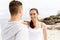 Runners. Young couple exercising and stertching on beach