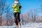 Running athlete woman sprinting in winter forest. Training outside in cold snowy weather