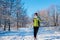 Running athlete woman sprinting in winter forest. Training outside in cold snowy weather